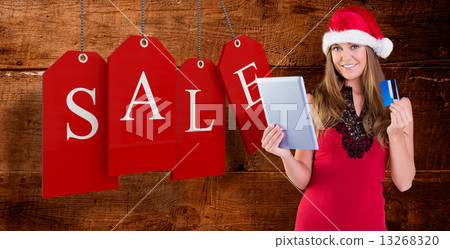 Composite image of festive blonde shopping online with tablet 13268320