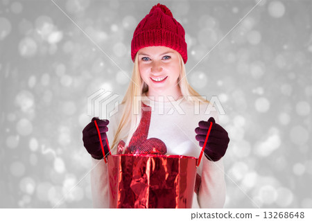 Composite image of festive blonde opening a gift bag Composite image of festive blonde opening a gift bag 13268648