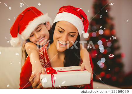 Composite image of festive mother and daughter smiling at camera 13269029