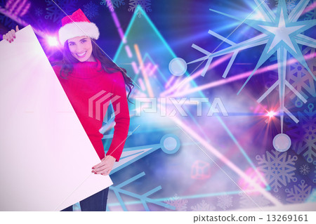 Composite image of smiling brunette in santa hat showing white p Composite image of smiling brunette in santa hat showing white p 13269161