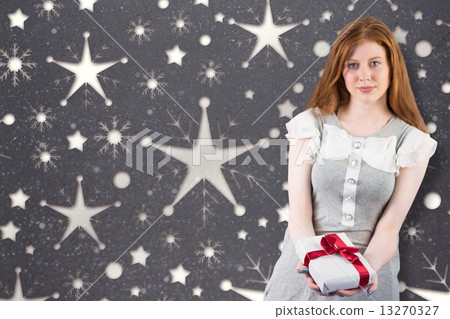 Composite image of pretty redhead offering a gift 13270327