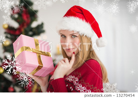 Composite image of festive woman standing holding a pink gift Composite image of festive woman standing holding a pink gift 13270454