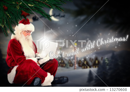Composite image of santa sits and uses a laptop 13270608