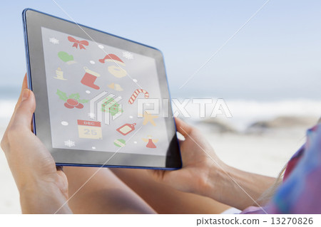 Composite image of woman sitting on beach in deck chair using ta Composite image of woman sitting on beach in deck chair using ta 13270826