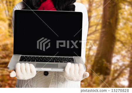 Composite image of woman holding a laptop computer Composite image of woman holding a laptop computer 13270828
