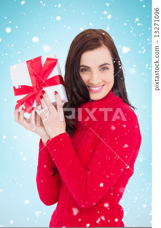 Composite image of smiling brunette in red jumper hat showing a Composite image of smiling brunette in red jumper hat showing a 13271096