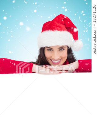 Composite image of beauty brunette in santa hat smiling at camer Composite image of beauty brunette in santa hat smiling at camer 13271126
