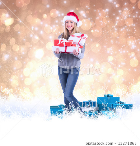 Composite image of festive blonde holding pile of gifts 13271863