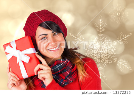 Composite image of smiling brunette in red hat holding gift Composite image of smiling brunette in red hat holding gift 13272255