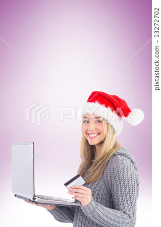 Festive blonde shopping online with laptop 13272702