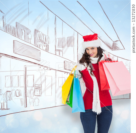 Composite image of smiling brunette in winter wear holding shopp 13272830