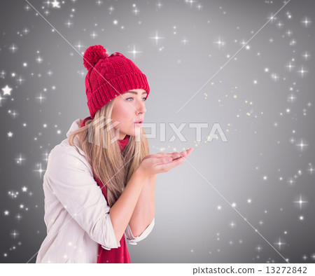 Composite image of happy blonde blowing over hands Composite image of happy blonde blowing over hands 13272842