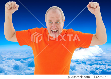 Composite image of mature man in orange tshirt cheering Composite image of mature man in orange tshirt cheering 13273138
