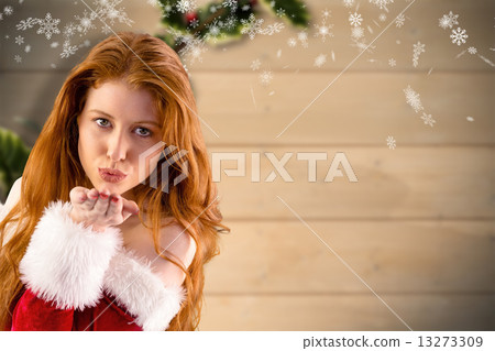 Composite image of festive redhead blowing a kiss 13273309