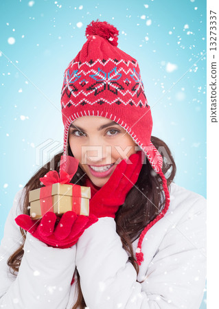 Composite image of surprised brunette in winter clothes holding Composite image of surprised brunette in winter clothes holding 13273337