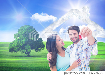 Composite image of happy young couple showing new house key 13273636