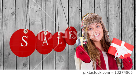 Composite image of happy blonde in winter clothes holding gifts Composite image of happy blonde in winter clothes holding gifts 13274865