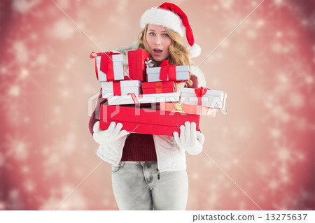 Composite image of blonde woman in trouble holding pile of gifts 13275637