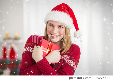 Composite image of festive pretty woman hugging her gift 13275688
