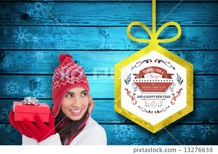 Composite image of happy brown hair holding red gift Composite image of happy brown hair holding red gift 13276638