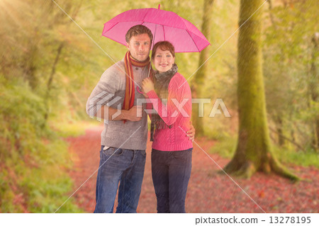Composite image of couple standing underneath an umbrella 13278195