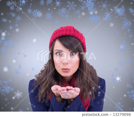 Composite image of festive brunette blowing over hands 13279098