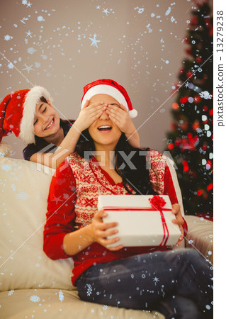Composite image of daughter surprising her mother with christmas gift Composite image of daughter surprising her mother with christmas gift 13279238
