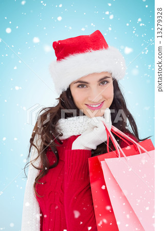 Composite image of cheerful brunette in winter wear holding shop Composite image of cheerful brunette in winter wear holding shop 13279328