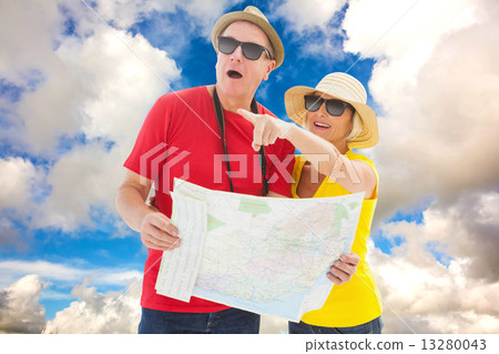Composite image of happy tourist couple using map Composite image of happy tourist couple using map 13280043