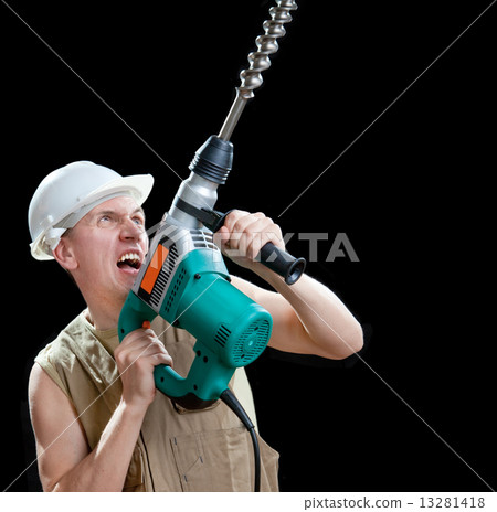 The builder in a protective helmet holds the professional puncher-hammer with a drill of the big dia The builder in a protective helmet holds the professional puncher-hammer with a drill of the big dia 13281418