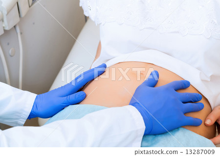 of doctor's hands on the belly of a pregnant woman of doctor's hands on the belly of a pregnant woman 13287009