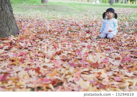 Children sitting on fallen leaves 13294819