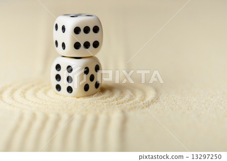 Two white dice with black dots on sand Two white dice with black dots on sand 13297250
