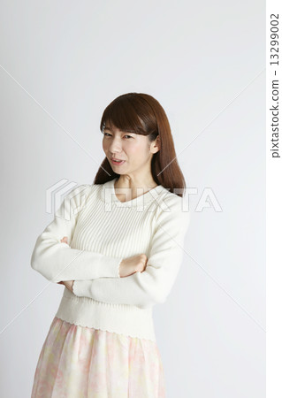 A young woman smiling with her arms folded A young woman smiling with her arms folded 13299002