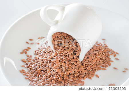 Organic brown flaxseed heap on white background Organic brown flaxseed heap on white background 13303293