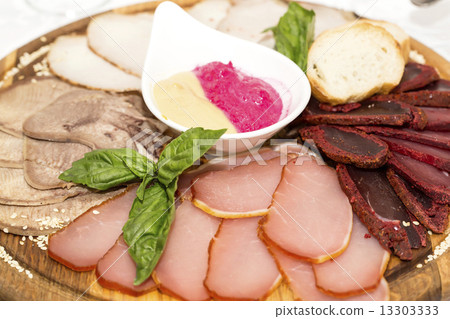 plate of sausages and bacon sauce on a table in a restaurant 13303333