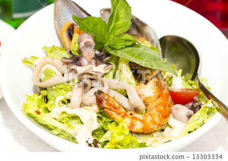 salad with vegetables and seafood on the table in a restaurant 13303334
