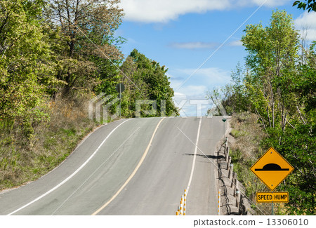 Hill on road with speed bump sign Hill on road with speed bump sign 13306010