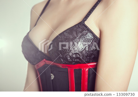 Close-up shot of a busty woman in black bra and corset 13309730
