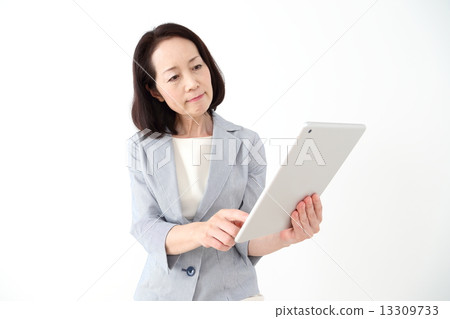 一個女人看著一台平板電腦，有一個困擾的臉 13309733