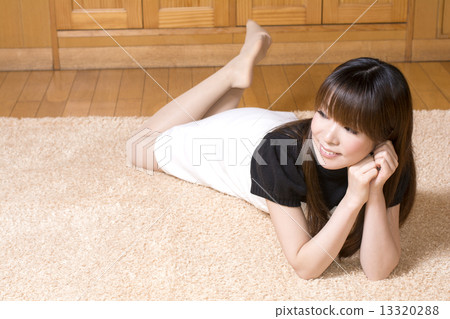 A lady lying on a rug mat 13320288