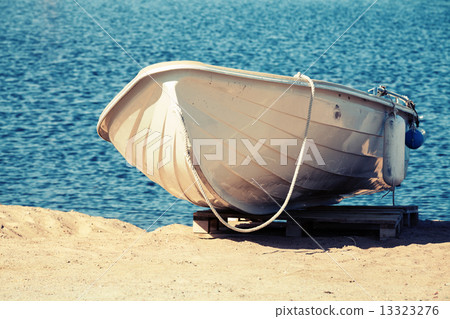 White rowboat stands on the sandy coast White rowboat stands on the sandy coast 13323276