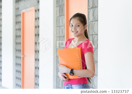 One young pan asian female student holding her notes file along campus corridor 13323737