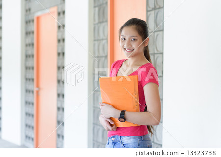 One young pan asian female student holding her notes file along campus corridor 13323738