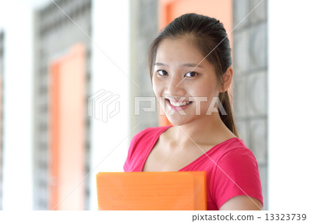 One young pan asian female student holding her notes file along campus corridor 13323739