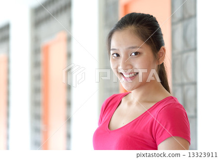 Portrait of one young pan asian female student along campus corridor 13323911