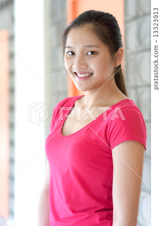 Portrait of one young pan asian female student along campus corridor 13323913