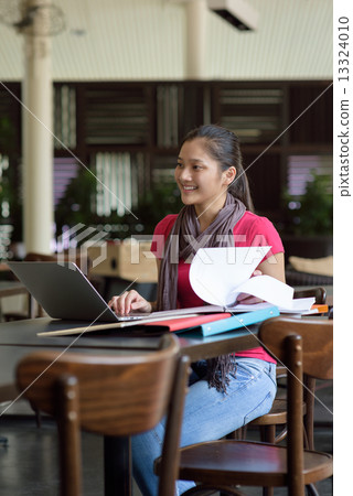One young pan asian female student studying in campus cafe 13324010