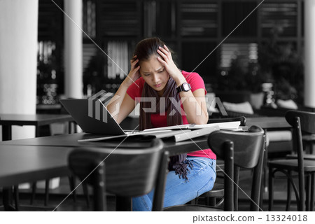 One young pan asian female student stressed over examination in campus cafe One young pan asian female student stressed over examination in campus cafe 13324018