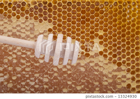 Wooden spoon for honey on honeycomb background. Wooden spoon for honey on honeycomb background. 13324930